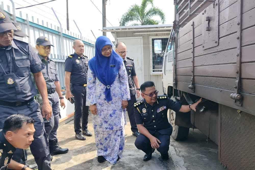 Ketua Pegawai Penguat kuasa KPDN Pahang, Muhamad Radzi Johari (kanan) bersama Jezlily menunjukkan tangki yang diubah suai untuk menyedut diesel yang diisi ke tangki tambahan di bahagian muatan lori digunakan.