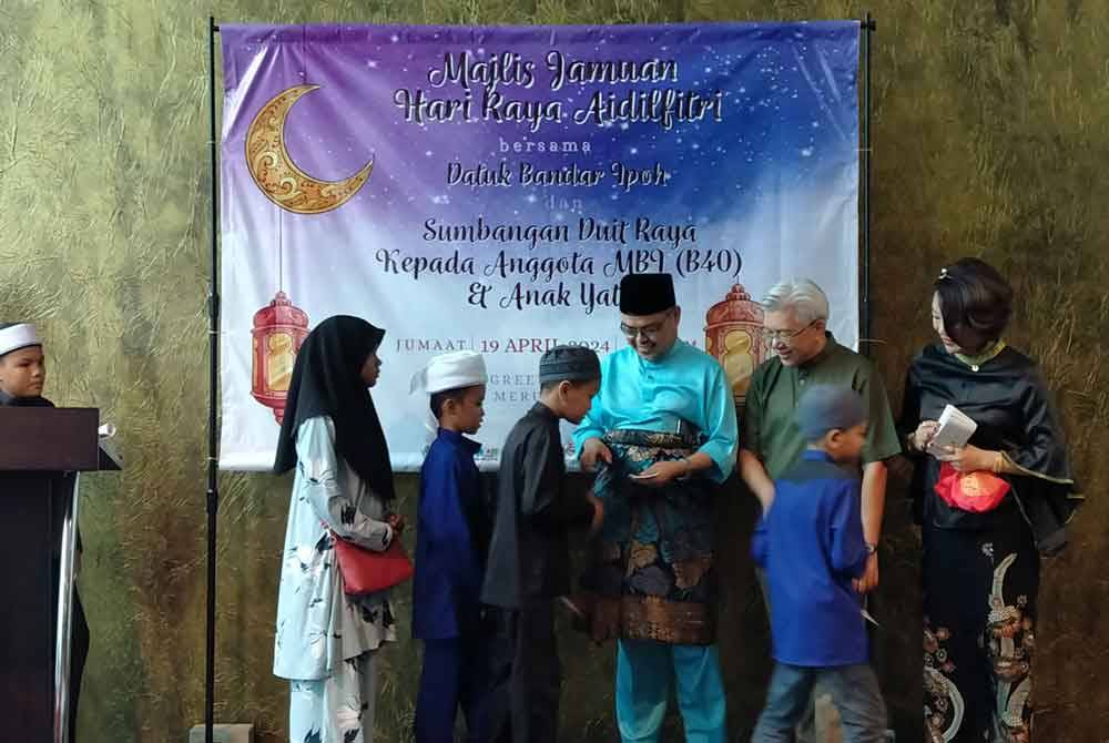 Rumaizi (tiga dari kanan) menyampaikan sumbangan kepada anak-anak yatim sempena Majlis Jamuan Hari Raya Aidilfitri dan Sumbangan Duit Raya kepada anggota MBI B40 dan Anak Yatim di sebuah restoran pada Jumaat.