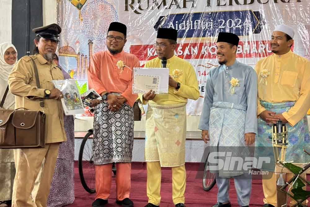 Takiyuddin (tiga dari kiri) membacakan kad ucapan hari raya yang disampaikan kepada beliau.