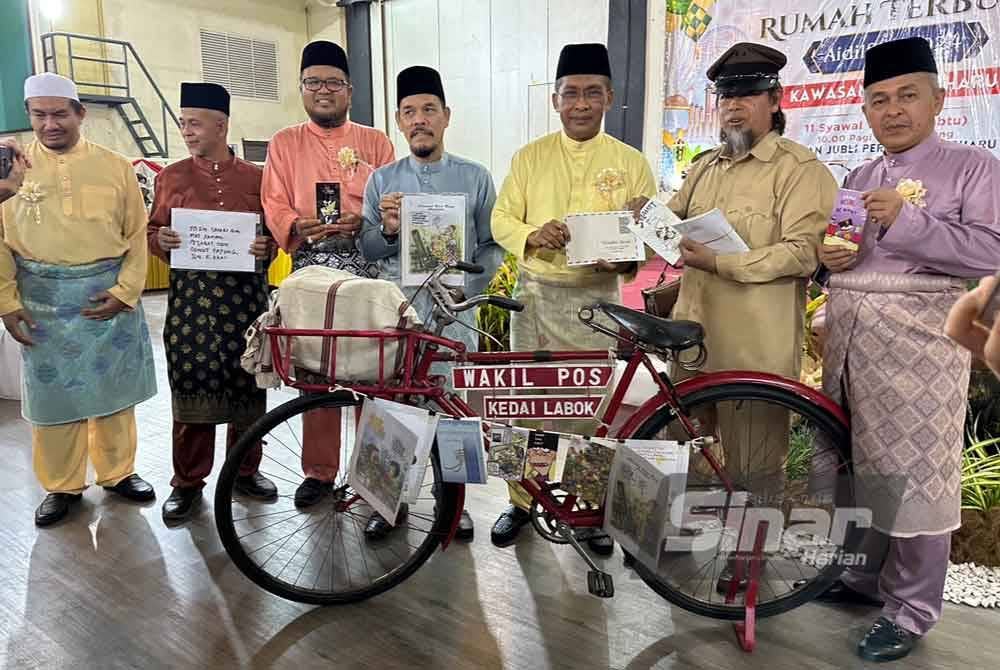 Simbolik perasmian majlis, Takiyuddin (tiga dari kiri) menerima kad raya yang disampaikan oleh posmen.