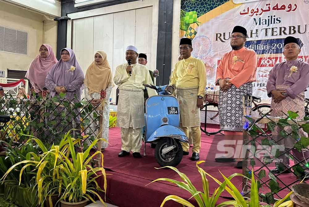Takiyuddin (tiga dari kanan) melayani Mohd Nassuruddin (empat dari kiri) dan tetamu yang hadir pada Majlis Rumah Terbuka Aidilfitri Pas Kota Bharu.