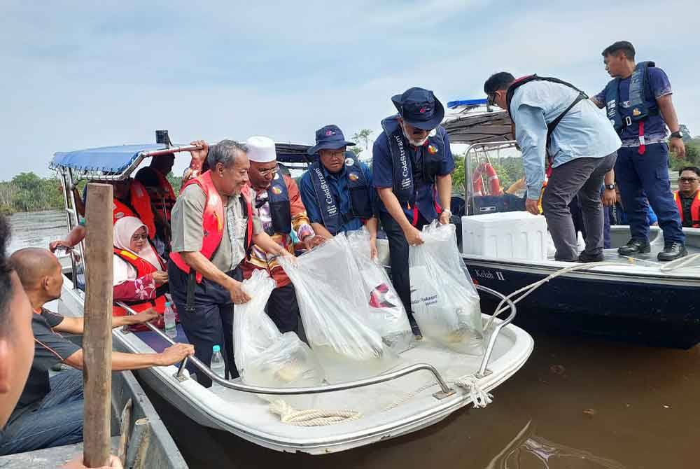 Adnan (dua dari kanan) melepaskan 100 induk ikan kelisa pada program Ramah Mesra DOF di Tasik Bukit Merah pada Sabtu.