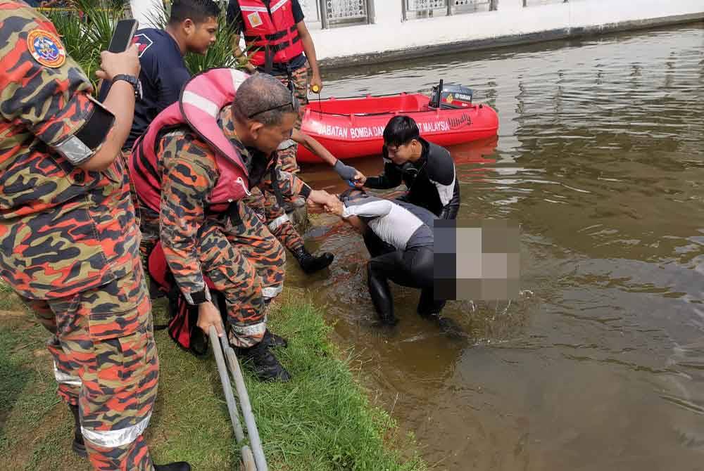 Pasukan penyelamat membawa mangsa ke tebing selepas berjaya ditemui di dasar tasik berhampiran Masjid An-Nur, Seri Iskandar. Foto: Ihsan Bomba Perak