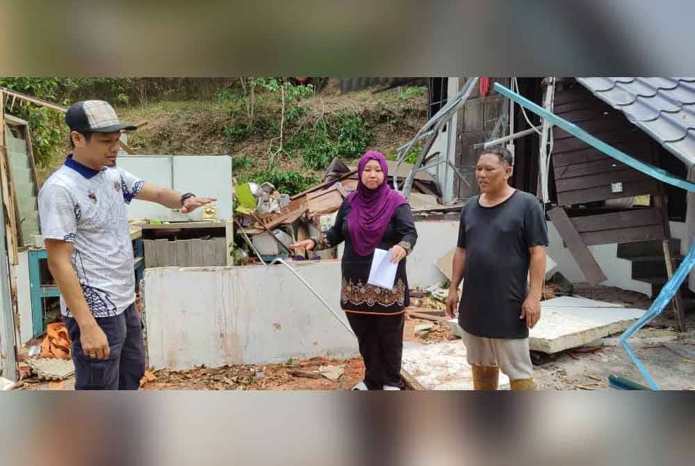 Mohd Zaffarin (kiri) ketika menyantuni Norhaslilee (tengah) di Kampung Petaseh Jelatang, Jelebu pada Sabtu.