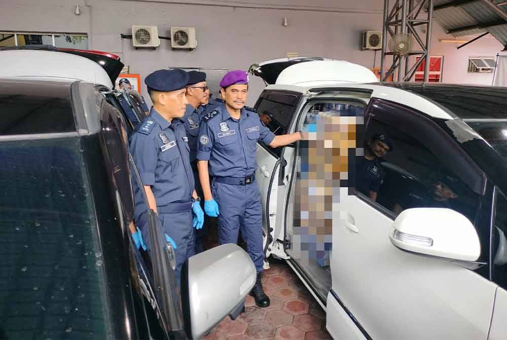 Sazali ( kanan) menunjukkan minuman keras tidak bercukai yang cuba diseludup keluar dari Forest City.