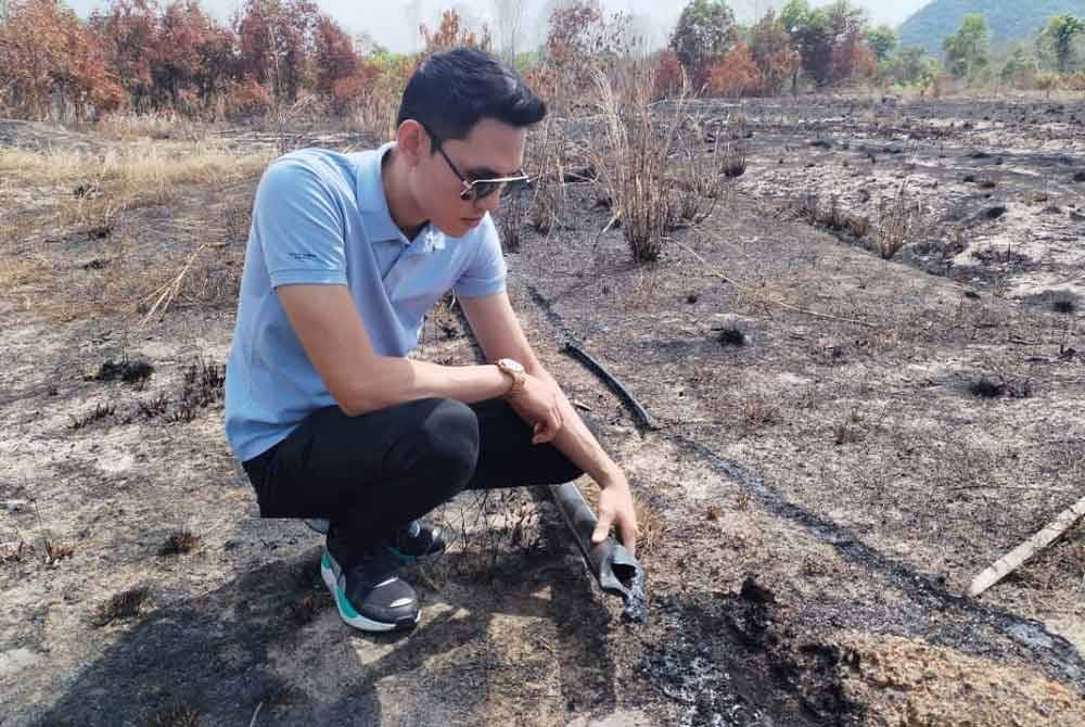 Tengku Mohammad Kamal melihat salah satu paip yang rosak kerana dijilat api.
