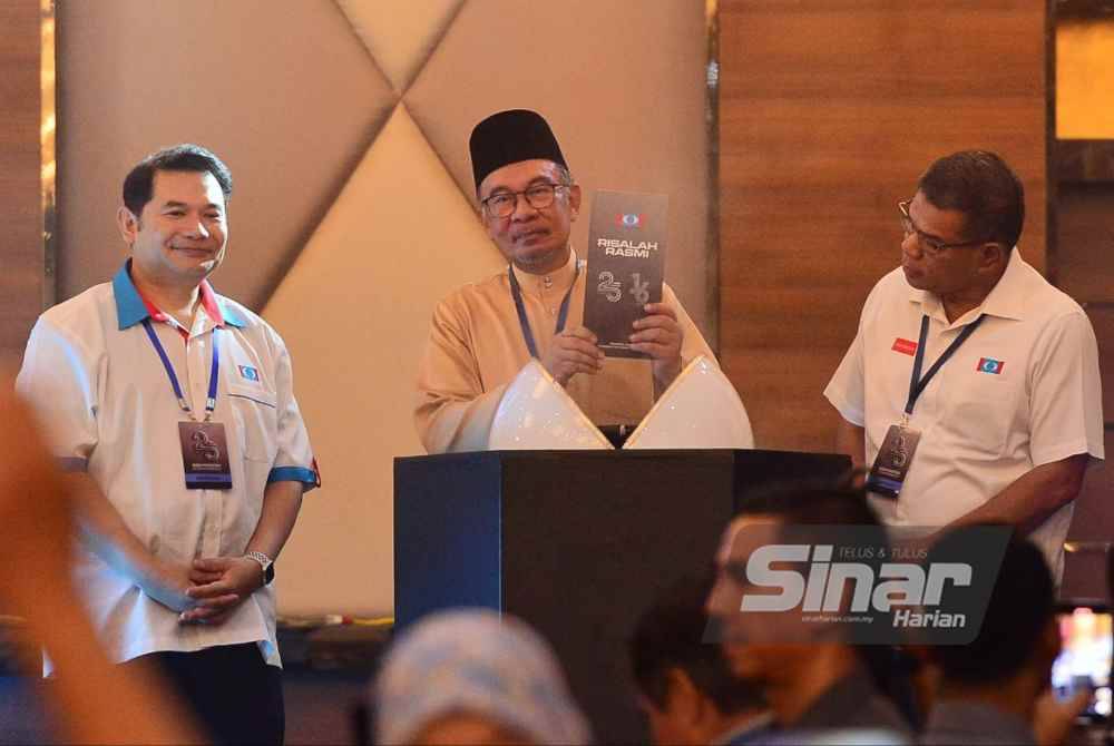 Anwar diapit Rafizi (kiri) dan Saifuddin ketika majlis pelancuran risalah KEMAS16 dan POP25 pada Konvensyen 25 Tahun PKR di IDCC, Shah Alam pada Ahad. Foto Sinar Harian-ASRIL ASWANDI SHUKOR.