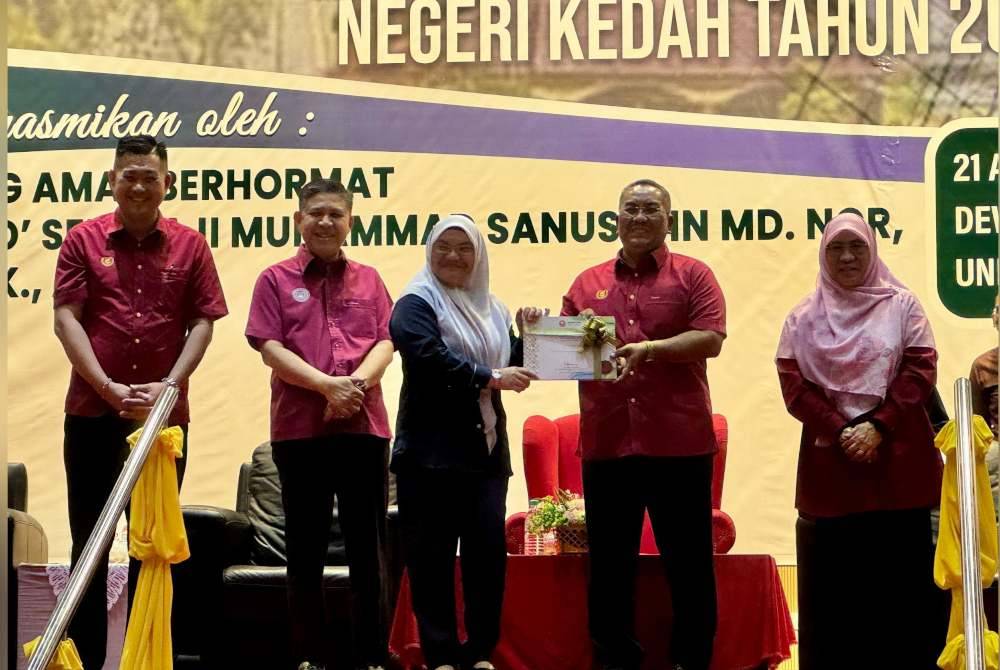 Sanusi menyampaikan watikah pelantikan kepada Pegawai Daerah Yan, Maznim Ismail (tengah) di Universiti Islam Antarabangsa Sultan Abdul Halim Muad'zam Shah di Kuala Ketil pada Ahad.