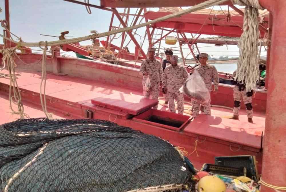 Erwan Shah (tengah) menunjukkan rampasan dalam operasi di perairan Malaysia pada Selasa lalu.