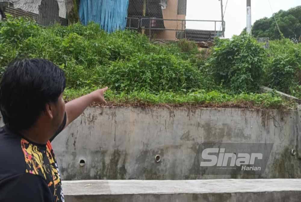 
Seorang penduduk menunjukkan tebing belakang sebuah rumah yang terjejas akibat hakisan di Kampung Sungai Rinting B, Pasir Gudang pada Isnin.