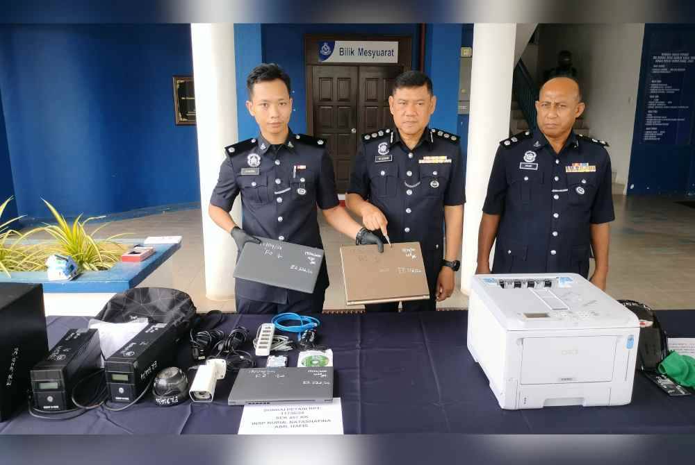 Wan Azharuddin (tengah) menunjukkan peralatan pejabat yang dicuri pengawal keselamatan ketika bertugas semasa Hari Raya Aidilfitri lalu.