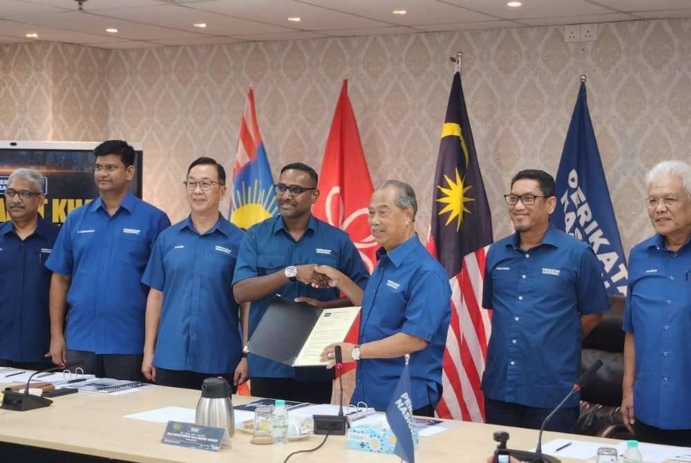 Muhyiddin (tiga dari kanan) berjabat tangan dengan Punithan.