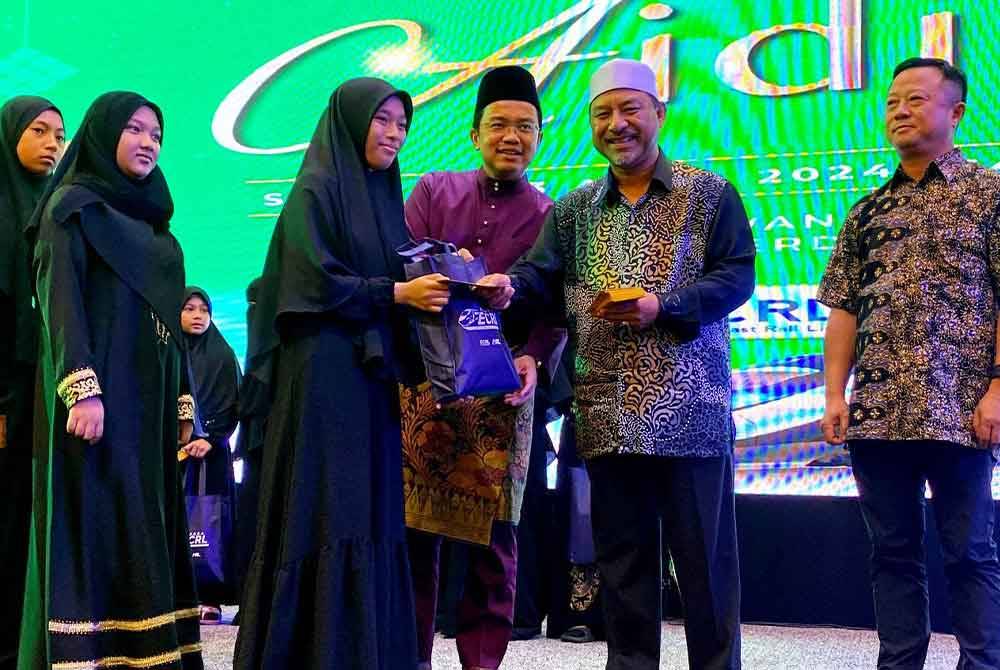 Mohd Nassuruddin (dua,kanan) menyampaikan sumbangan kepada anak-anak yatim semasa Majlis Rumah Terbuka Aidilfitri Projek Laluan Rel Pantai Timur (ECRL) di sini pada Selasa.