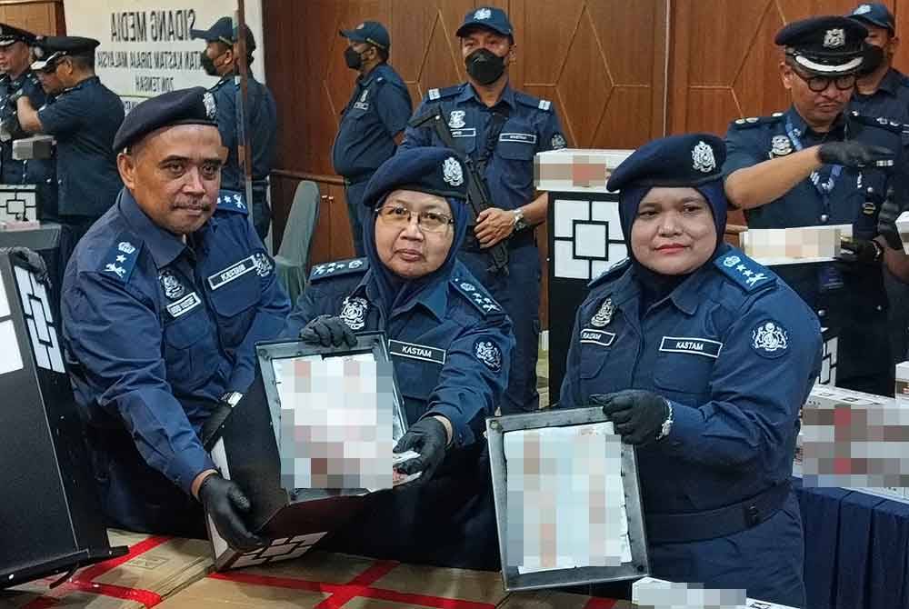 Norlela (tengah) menunjukkan rokok putih yang disorokkan dalam kotak lampu laman cuba diseludup masuk ke negara ini. Foto SINAR HARIAN - HISYAMUDDIN AYUB.