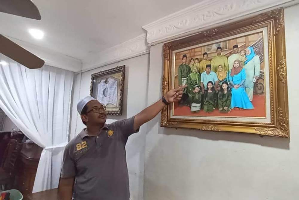 Abdul Latif menunjukkan foto kenangan adik perempuannya bersama keluarganya.