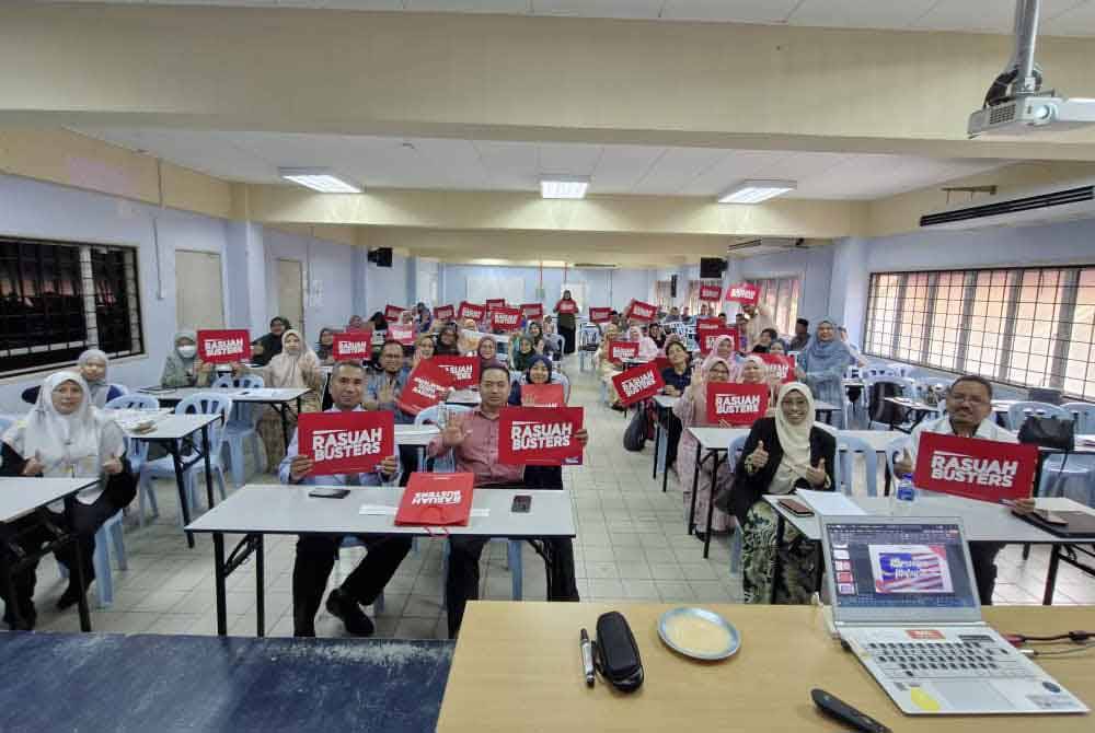 Nurhayati (dua dari kanan) bersama pihak pengurusan, guru dan staf MRSM Kuala Kubu Baru, memegang plakad Rasuah Busters sebagai tanda sokongan menentang rasuah.