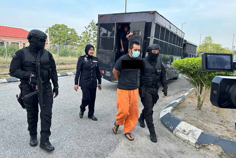 Suspek (dua dari kanan) yang dikawal ketat polis tiba di Kompleks Mahkamah Kota Bharu.