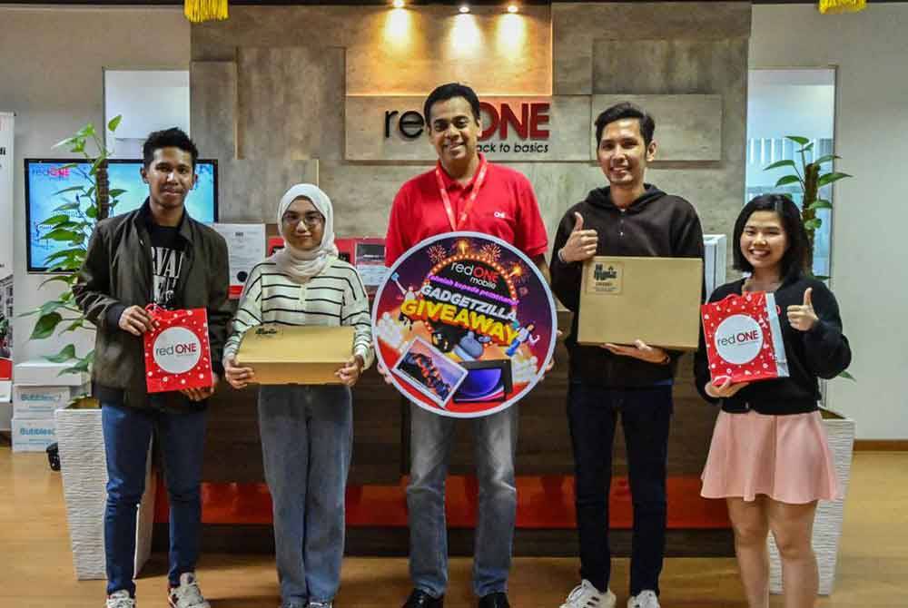 Ketua Pegawai Eksekutif, redONE Mobile, Ameen Amaendran (tengah) menyampaikan hadiah kepada pemenang pertandingan 'Gadgetzilla Giveaway' di pejabat pusat redONE Mobile, Puchong.
