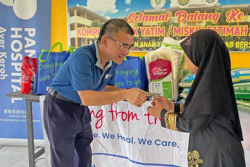 Yew Aik memberikan sumbangan duit raya kepada penghuni Kompleks Anak Yatim Miskin Fatimah Al-Zaharah.