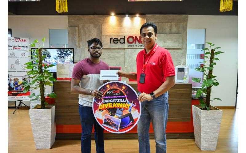 Ketua Pegawai Eksekutif redONE Mobile, Ameen Amaendran, menyampaikan hadiah kepada pemenang pertandingan Gadgetzilla Giveaway di pejabat pusat redONE Mobile di Puchong.