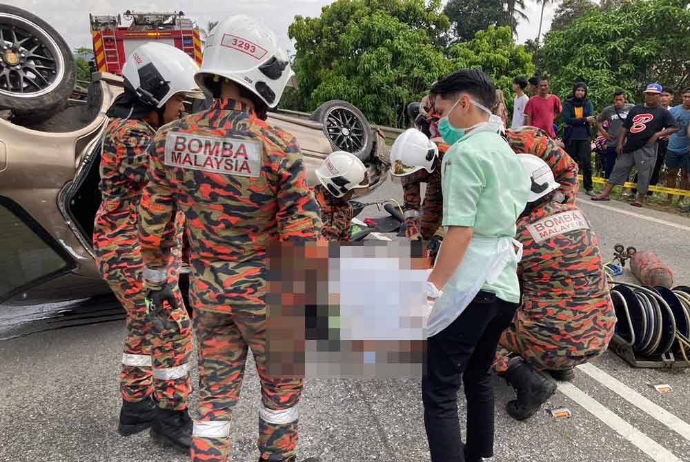 Pihak bomba bertungkus-lumus mengeluarkan mangsa lelaki yang tersepit.