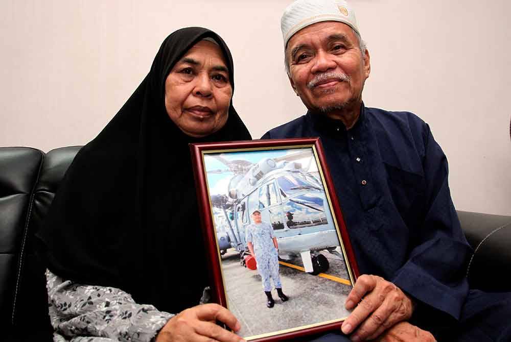 Mohd Termizi (kanan) dan Hasnah (kiri) menunjukkan gambar anak mereka Allahyarham Mohd Shahrizan ketika ditemui bual di kediamannya di Taman Bunga Tanjung Lekir pada Rabu. Foto Bernama