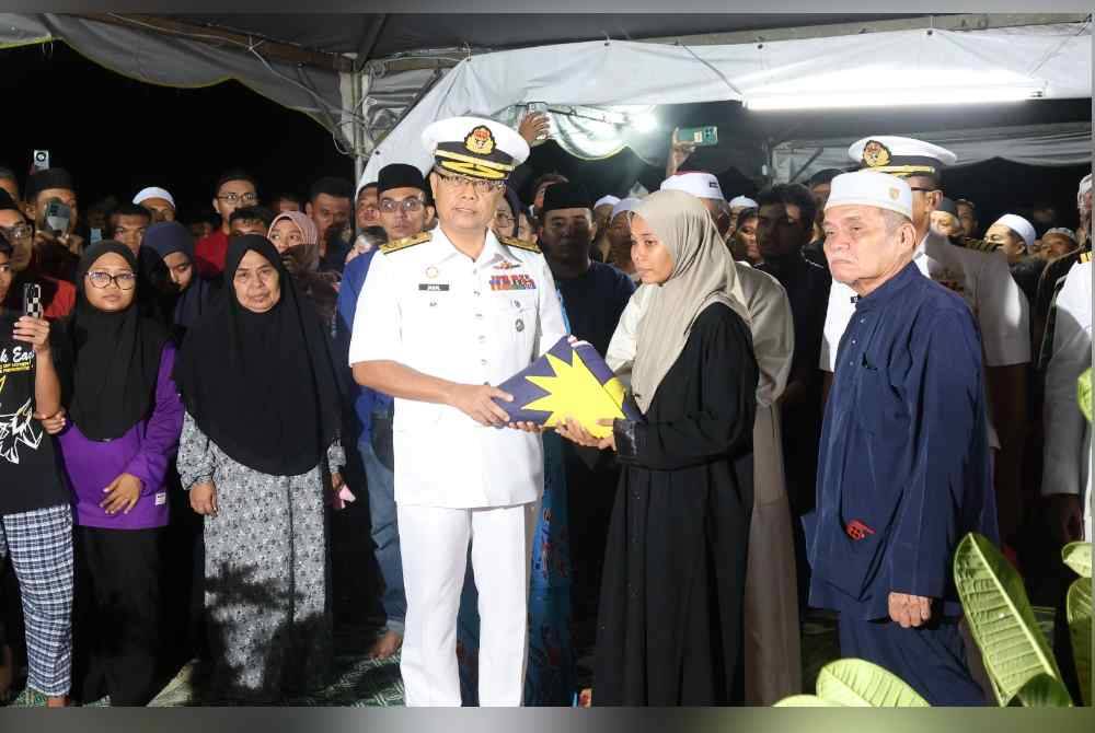 Jamaludin menyerahkan Ensign kepada Nurul Shahfiqah selepas selesai pengebumiannyang dijalankan mengikut istiadat rasmi pengurusan jenazah TLDM.