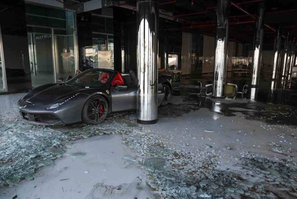 
Sebuah kereta mewah di salah sebuah bilik pameran rosak akibat banjir yang berlaku di ibu kota UAE, Dubai.