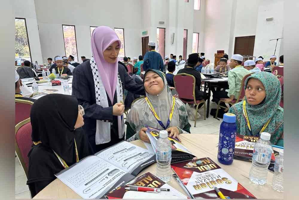 Ustazah Syahrul (dua dari kiri) membantu pelajar menghafaz al-Quran dengan teknik yang mudah dan betul.