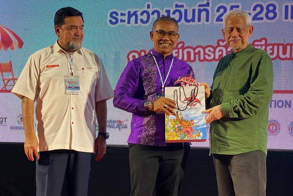 Kamarudin (kanan) menyampaikan cenderamata kepada deligasi yang hadir ke Festival Asia 2024 yang diadakan di Asean Mall Pattani, Thailand.