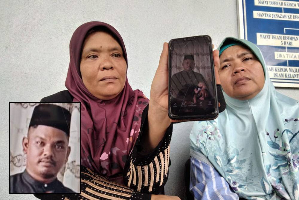 Juhasni Naini (kiri) dan Juhaslina menunjukkan gambar Juhazrie, mangsa kemalangan maut membabitkan dua kenderaan pacuan empat roda di Jalan Kuala Krai-Gua Musang pada awal pagi Sabtu.
