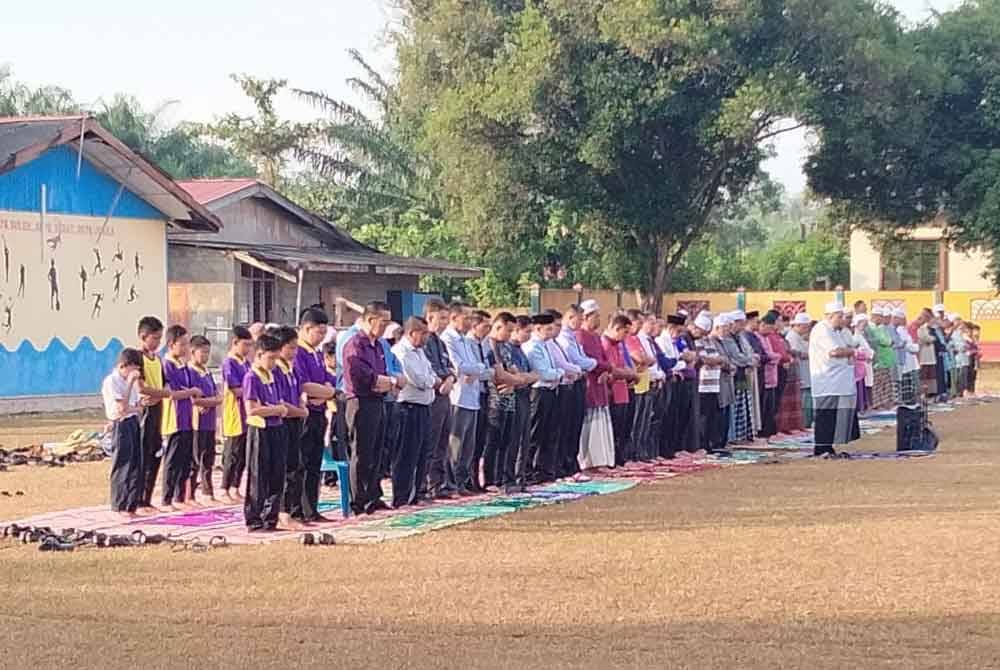 Jemaah Masjid Mukim Padang Kala dan warga SK Padang Kala menunaikan solat di atas padang sekolah berkenaan.