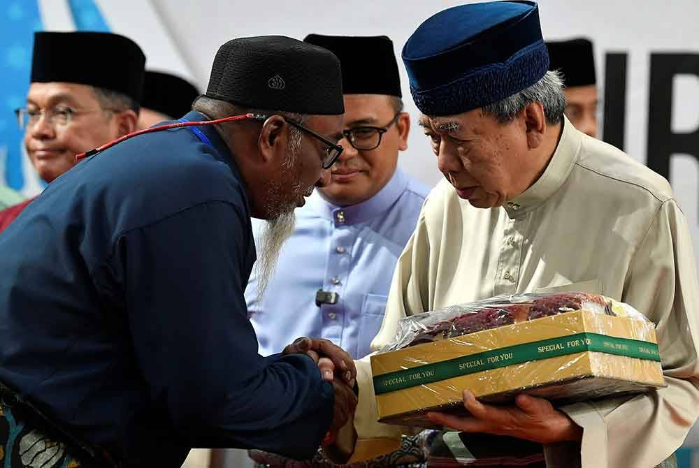 Sultan Sharafuddin (kanan) berkenan menyampaikan cenderamata kepada wakil bakal-bakal haji kurniaan dan bakal-bakal haji mewakili daerah ketika berangkat menyempurnakan Kursus Perdana Haji Peringkat Negeri Selangor bagi tahun 1445H/2024 di Masjid Sultah Salahuddin Abdul Aziz Shah pada Ahad.Foto Bernama