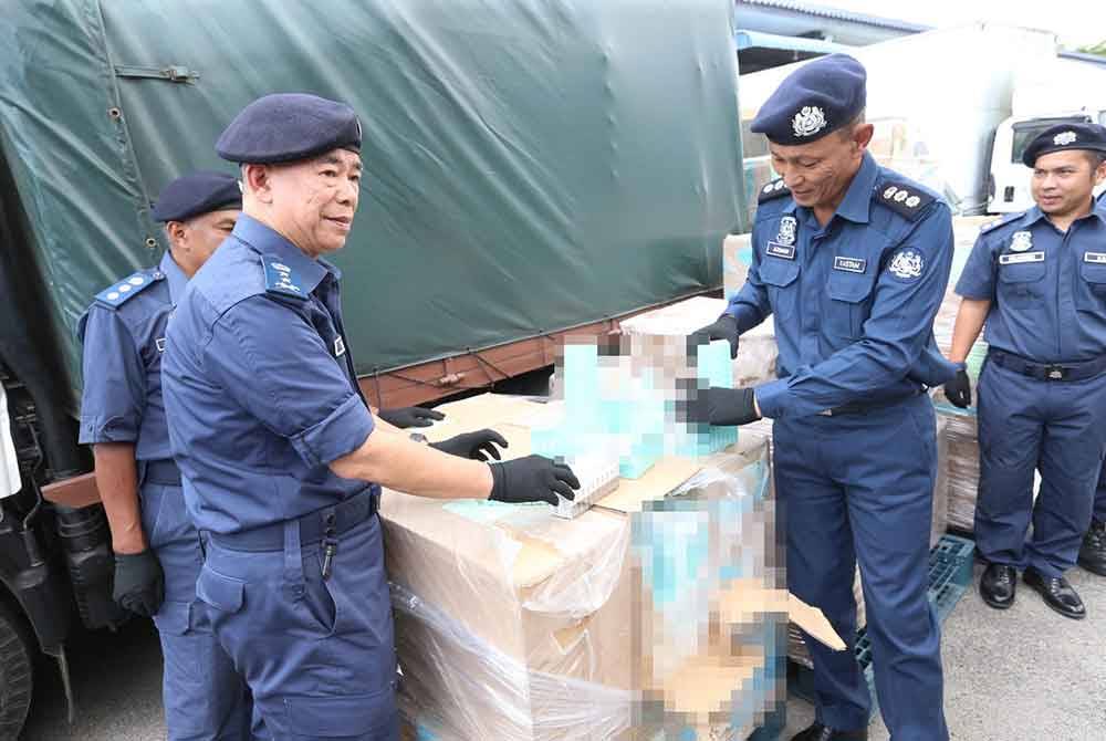 Wan Jamal Abdul Salam (kiri) menunjukkan barangan yang dirampas semasa sidang akhbar pada Ahad.