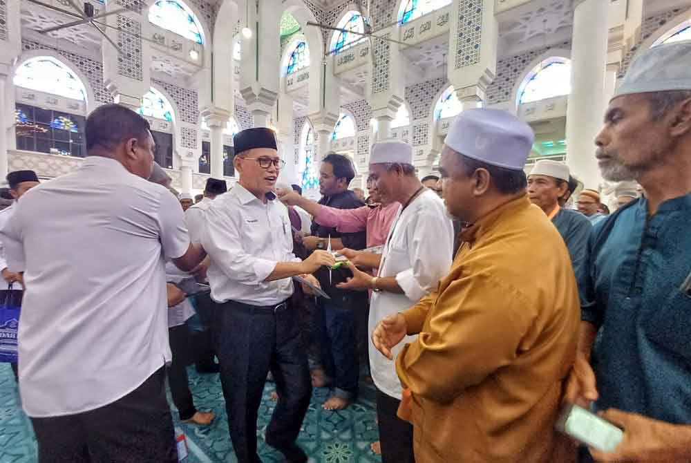 Wan Rosdy menyampaikan bantuan RM750 kepada jemaah haji Pahang pada Majlis Perasmian Kursus Perdana Haji dan Penyampaian Barakah Haji Pahang 2024 di Masjid Negeri Sultan Ahmad 1, di Kuantan pada Ahad.