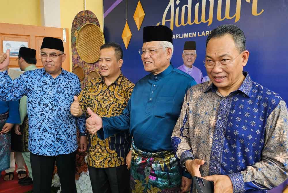 Hamzah (dua dari kanan) bergambar bersama tetamu yang hadir pada sambutan Hari Raya Aidilfitri Parlimen Larut di Dewan Semai Bakti, Felda Ijok, Selama.