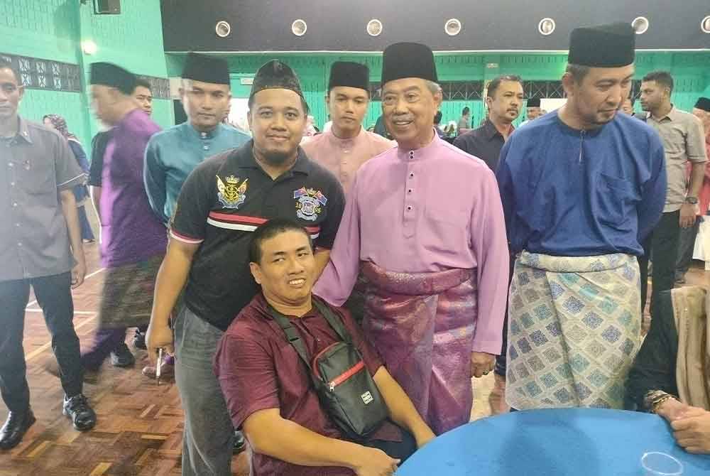 Muhyiddin (dua dari kanan) bergambar dengan tetamu yang hadir pada Majlis Rumah Terbuka Aidilfitri Parlimen Pagoh di Kompleks Sukan Pagoh, pada Ahad.