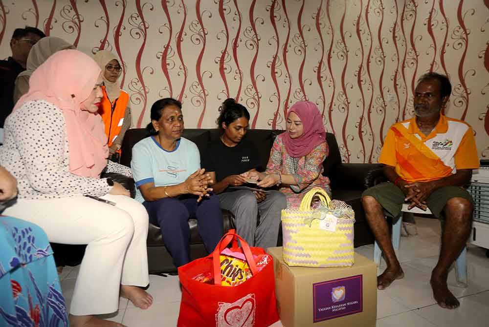 Noraini (dua, kanan) menyampaikan sumbangan kepada balu Leftenan Sivasutan. Foto Bernama