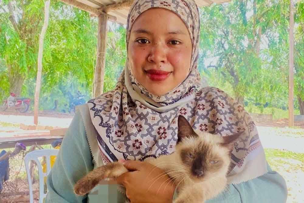 Nur Wahida menunjukkan kucing milik adiknya yang masih dijaga mereka sekeluarga.