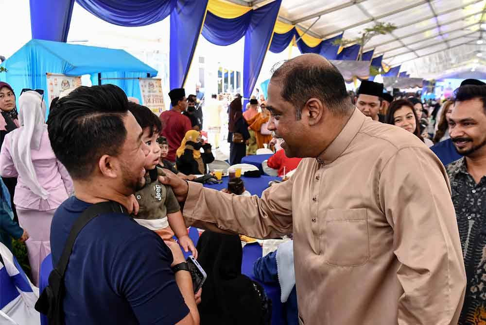 Ramanan (kanan) beramah mesra bersama pengunjung yang hadir pada Rumah Terbuka Aidilfitri di pekarangan Pusat Khidmat Rakyat Parlimen Sungai Buloh pada Ahad. Foto Bernama