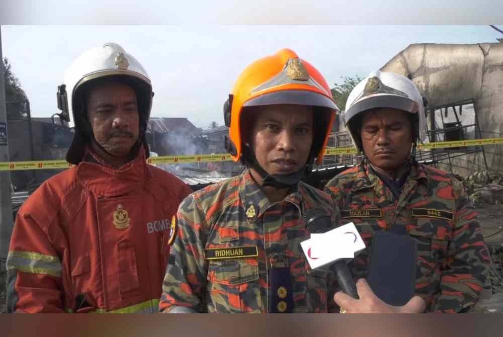 Ahmad Ridhuan (tengah) ketika memberi kenyataan kepada pemberita di Beris Kubur Besar, Bachok.
