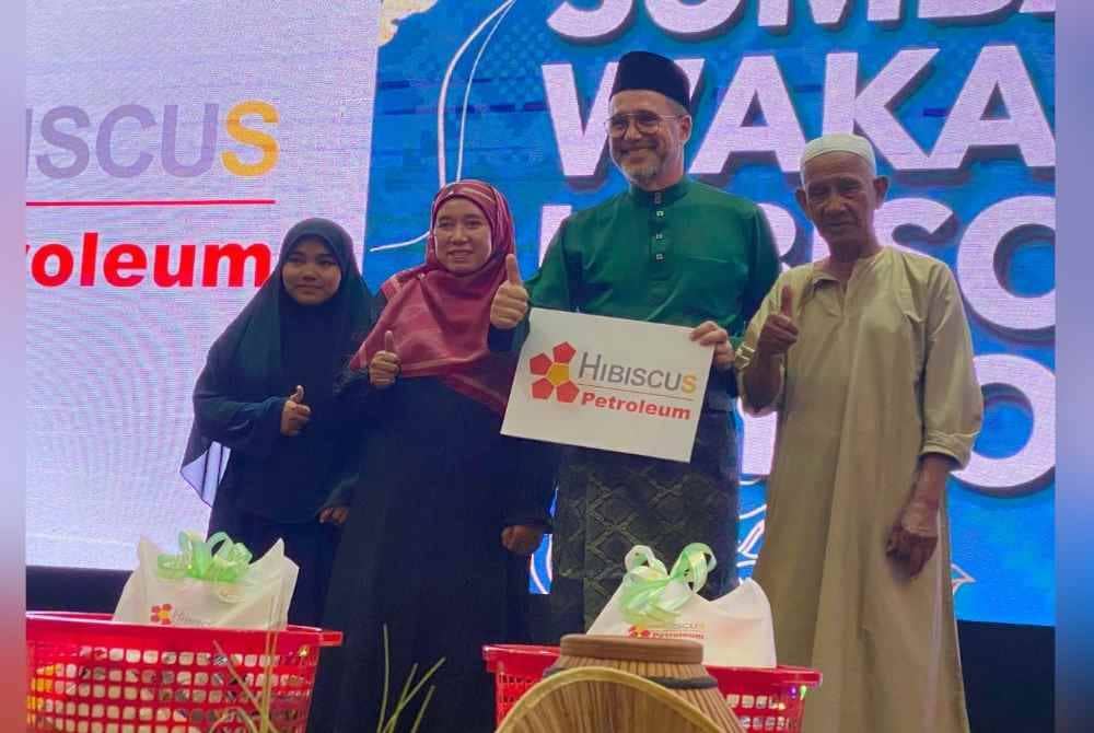 Dr Pascal (dua dari kanan) menyampaikan sumbangan kepada penerima semasa Majlis Rumah Terbuka Hari Raya pada Ahad.