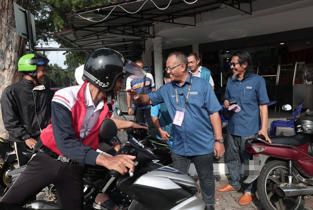 Calon PN turut menyantuni pengundi muda ketika jelajah mesra di Pekan Kuala Kubu Baharu.
