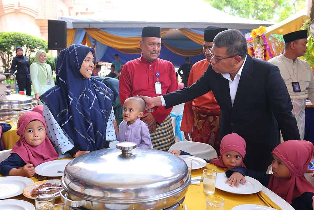 Saifuddin Nasution (kanan) menyantuni anak-anak yatim pada Majlis Perjumpaan Menteri Dalam Negeri Bersama Warga Maritim Malaysia. Foto Bernama