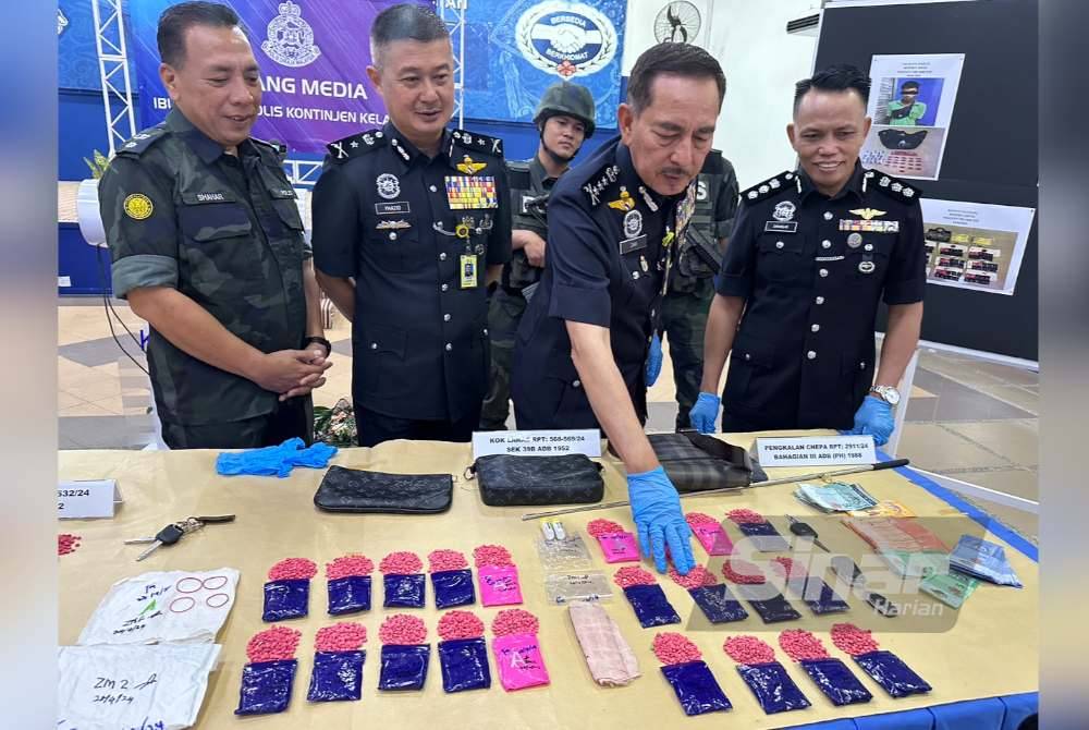 Muhamad Zaki (dua dari kanan) menunjukkan dadah yang dirampas dari dalam kereta suspek.