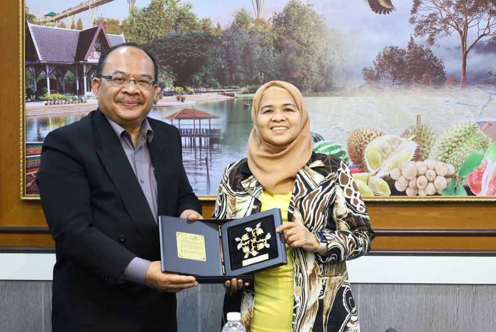 Mohd Foad (kiri) menyampaikan cenderahati kepada Pateemoh dalam kunjungan hormat berkenaan.