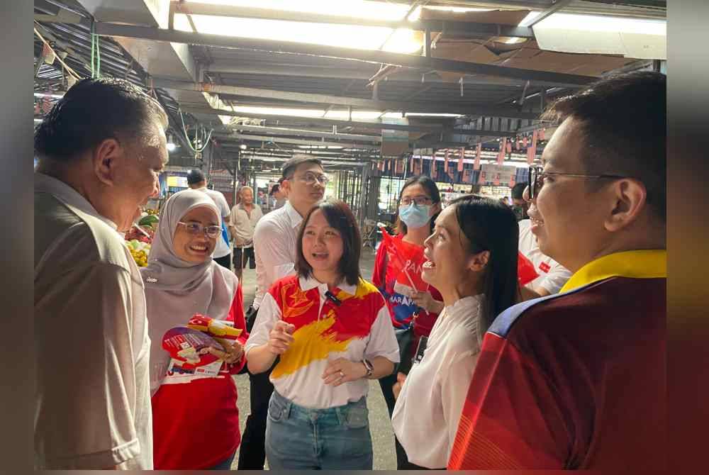 Nie Ching (dua dari kanan) ketika membantu kempen Sock Tao di Pasar Awam Kuala Kubu Baharu, pada Selasa.