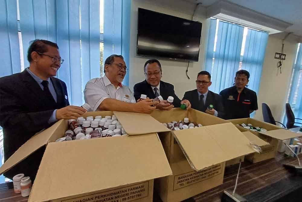 Rusdi (tengah) menunjukkan produk ubatan tidak berdaftar yang dijual secara dalam talian di bilik mesyuarat di Pejabat JKNP di Indera Mahkota pada Selasa