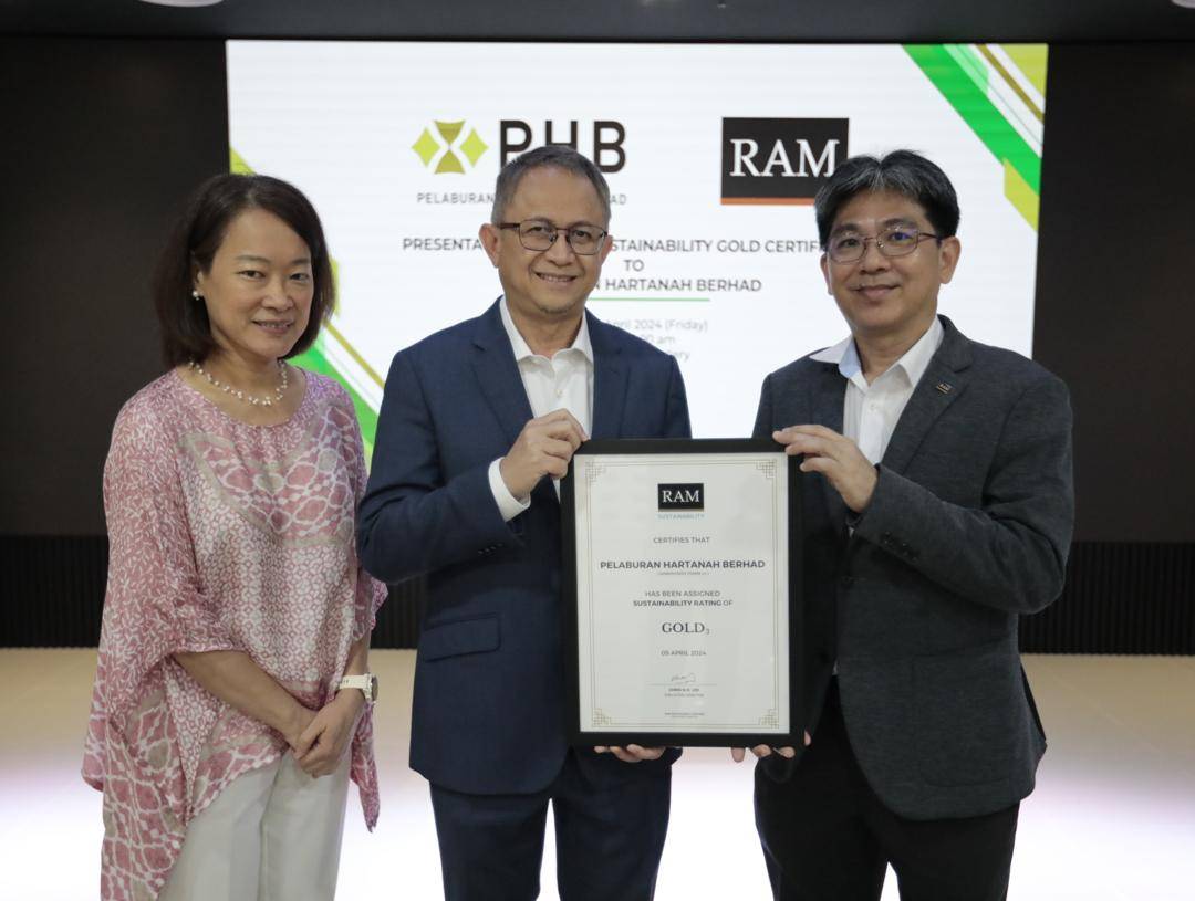 Pengarah Eksekutif RAM Ratings, Chris Lee (kanan), menyampaikan sijil penarafan kemampanan emas (G3) kepada Pengarah Urusan Kumpulan merangkap Ketua Pegawai Eksekutif PHB, Mohamad Damshal Awang Damit (tengah), disaksikan oleh Ketua Pegawai Eksekutif RAM Ratings, Julie Ng (kiri), di pejabat PHB.