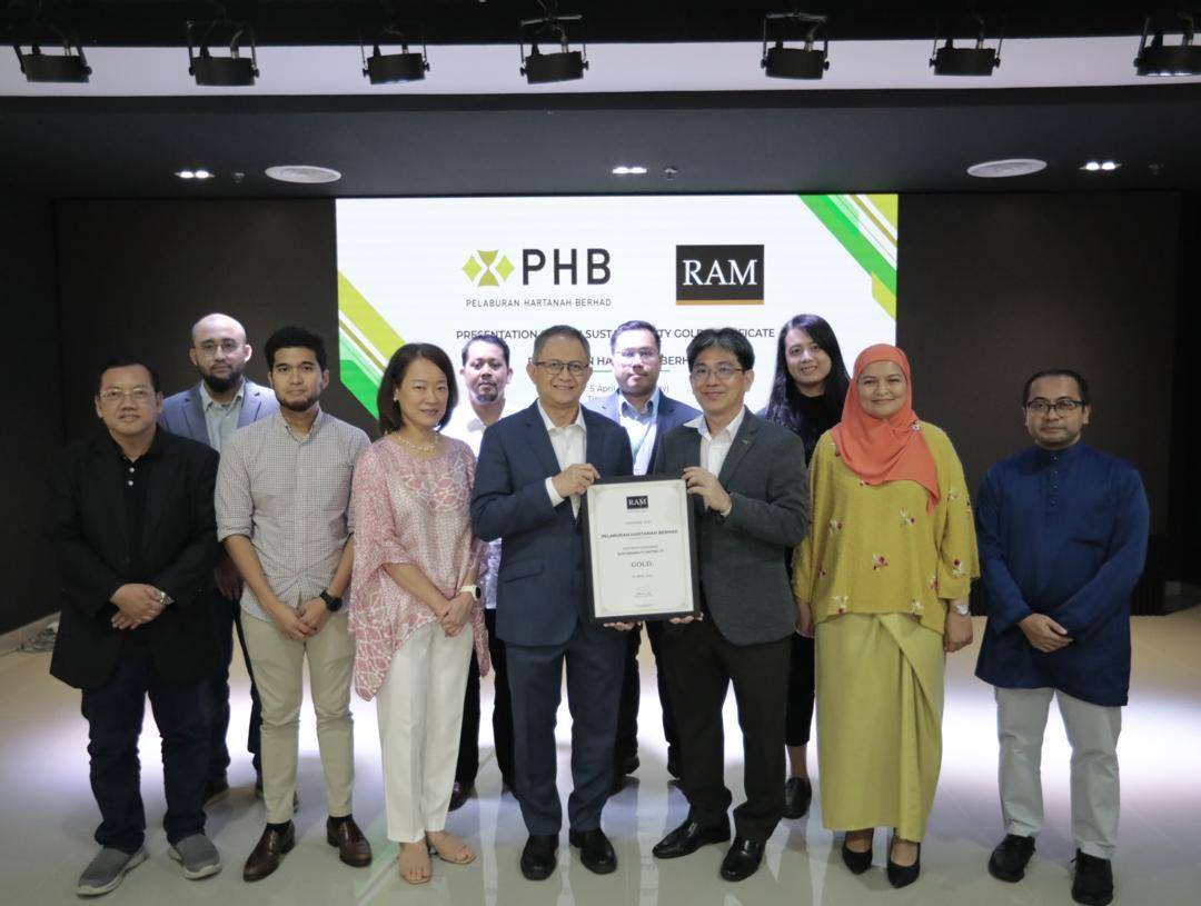 Pengarah Eksekutif RAM Ratings, Chris Lee (tiga dari kanan), menyampaikan sijil penarafan kemampanan emas (G3) kepada Pengarah Urusan Kumpulan merangkap Ketua Pegawai Eksekutif PHB, Mohamad Damshal Awang Damit (tengah) di pejabat PHB. 